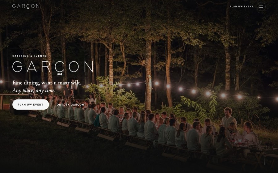 De homepage van Garçon: een lange gedekte tafel in een bos, met lichtjes.
